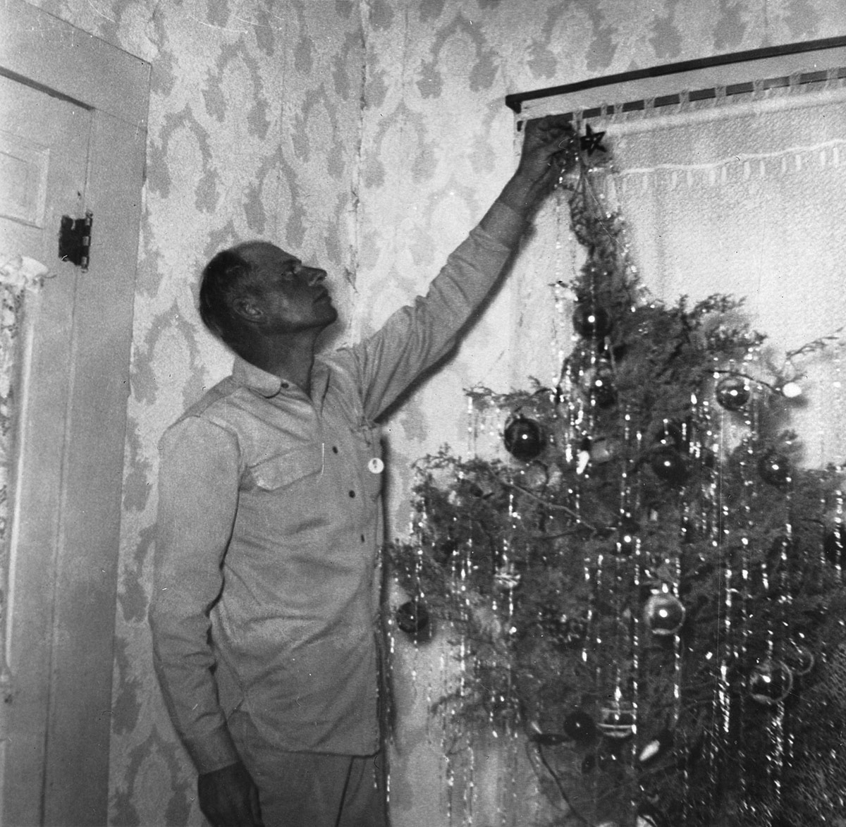 Man putting start on a Christmas Tree